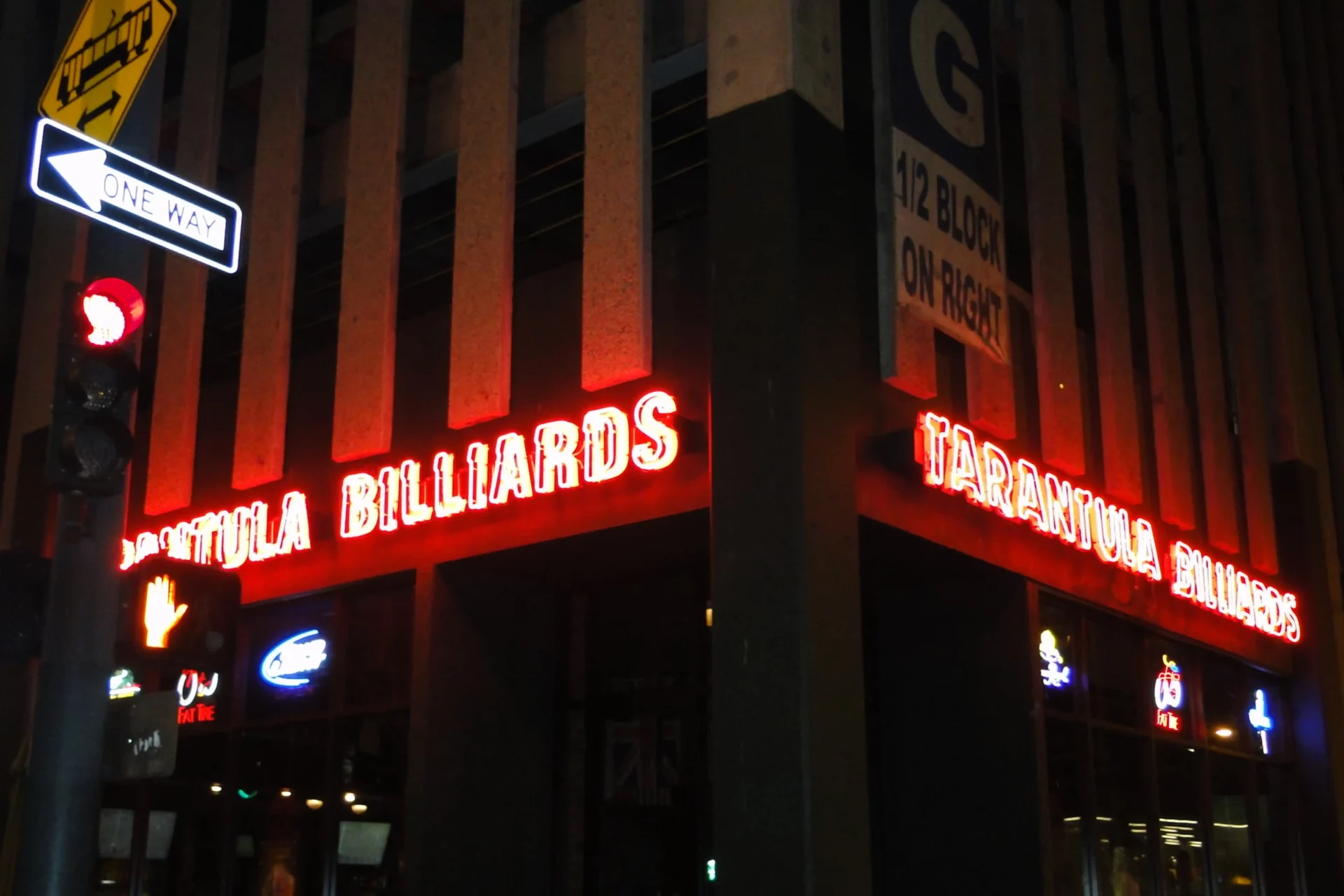 A neon sign is lit up on the side of a building.