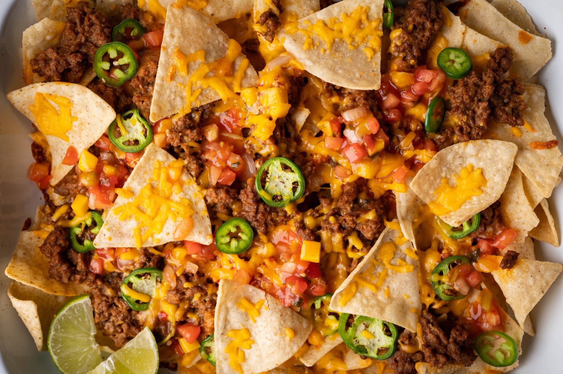 A close up of nachos with cheese and jalapenos