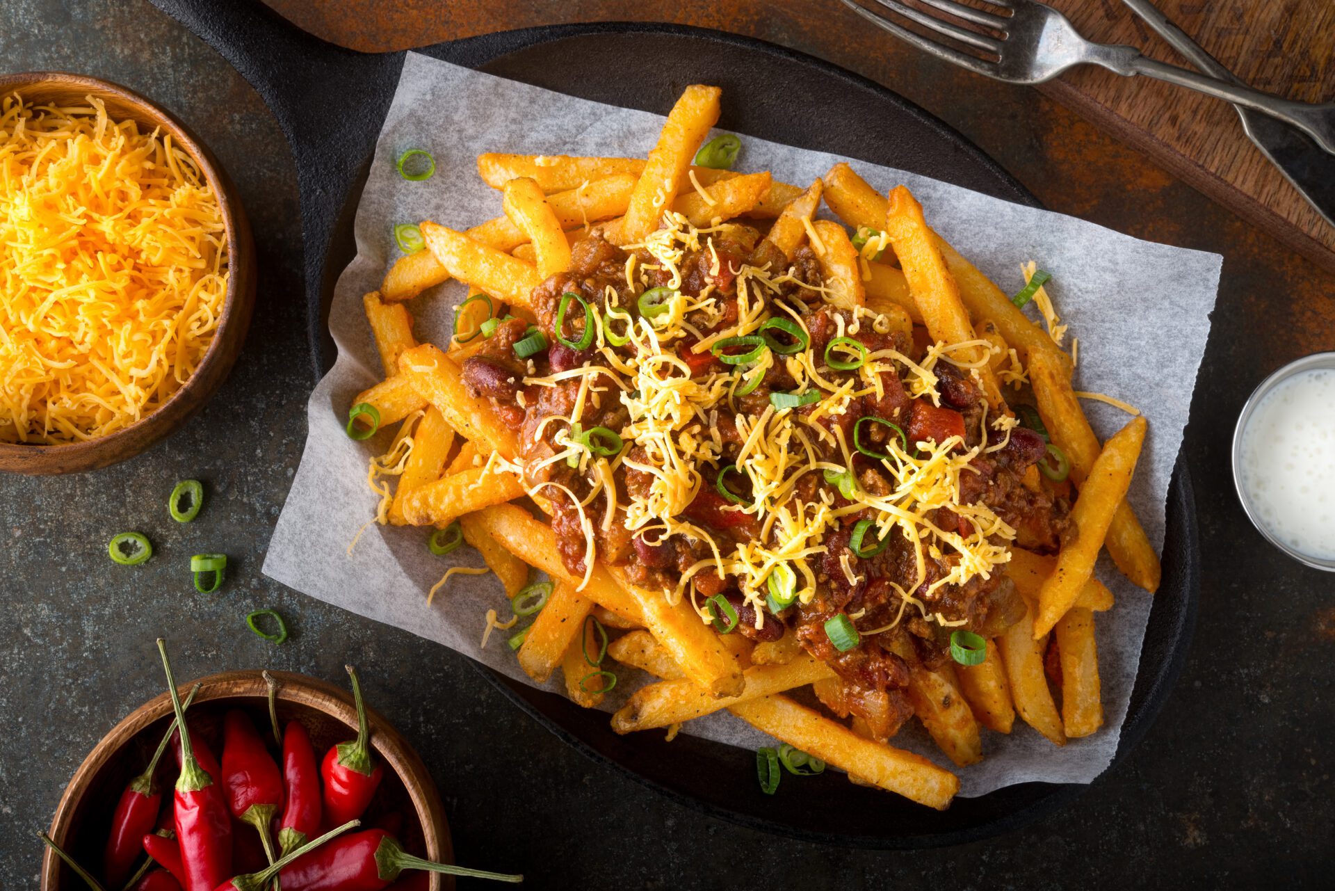 A plate of chili cheese fries with toppings.