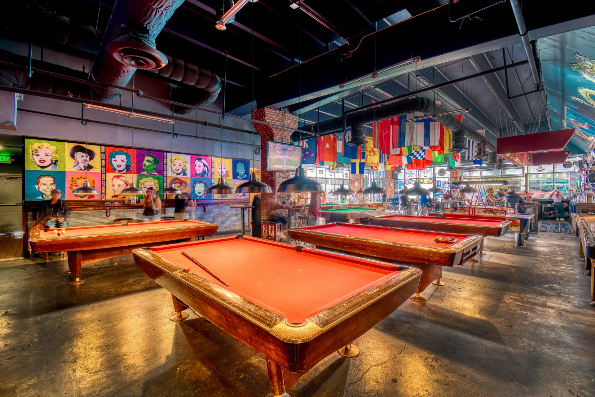 A group of people playing pool in an indoor room.